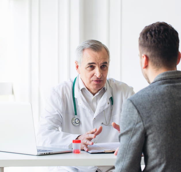 Врач беседует с пациентом в кабинете клиники