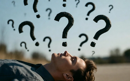 Мужчина лежит на спине, глядя вверх, вокруг него парят чёрные вопросительные знаки