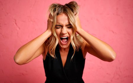 Девушка кричит схватив себя за волосы